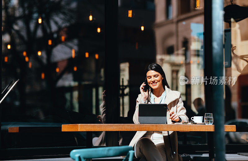Beautiful Woman Having a Business Call in a Café on a Sunny Day